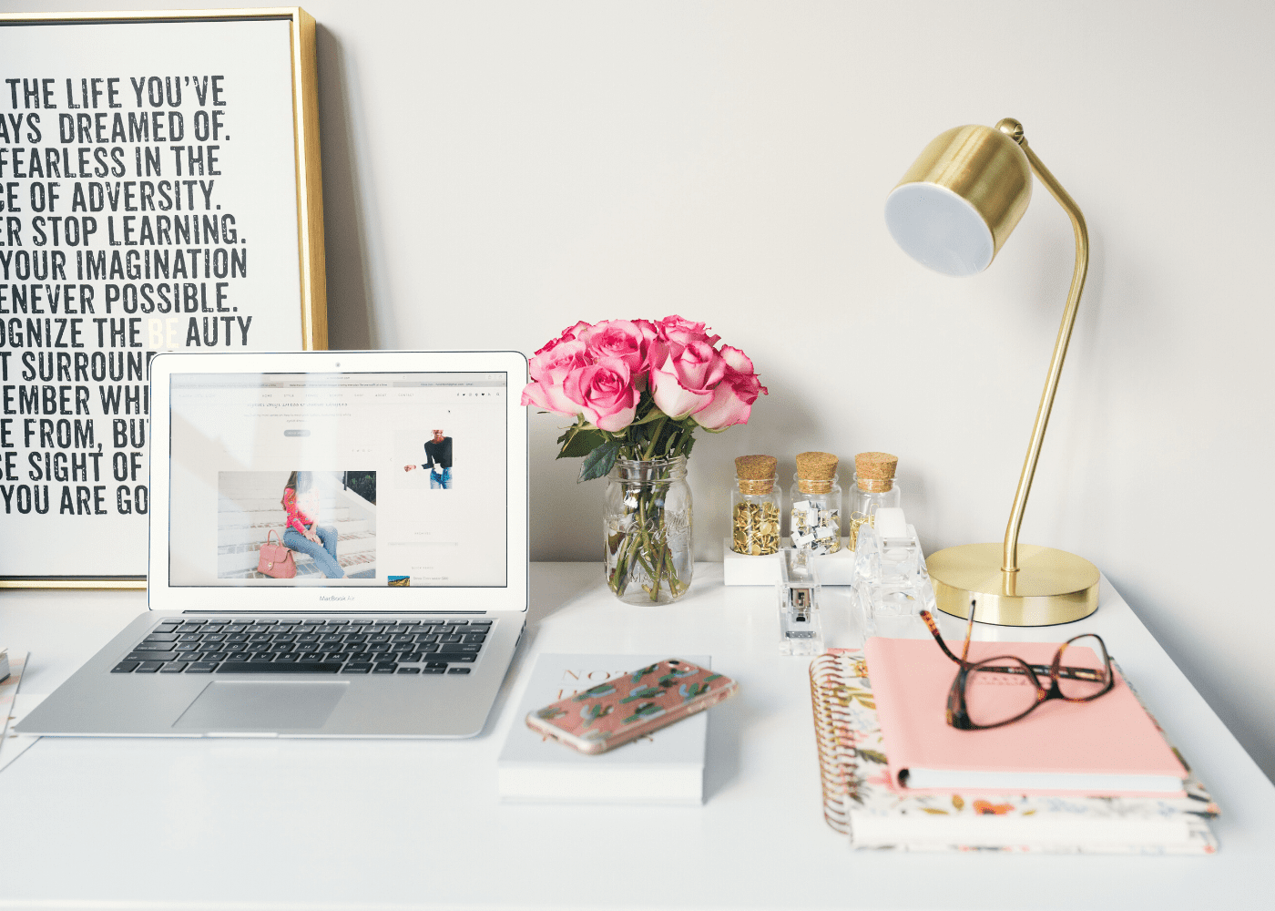 desk with flowers, computer and lamp