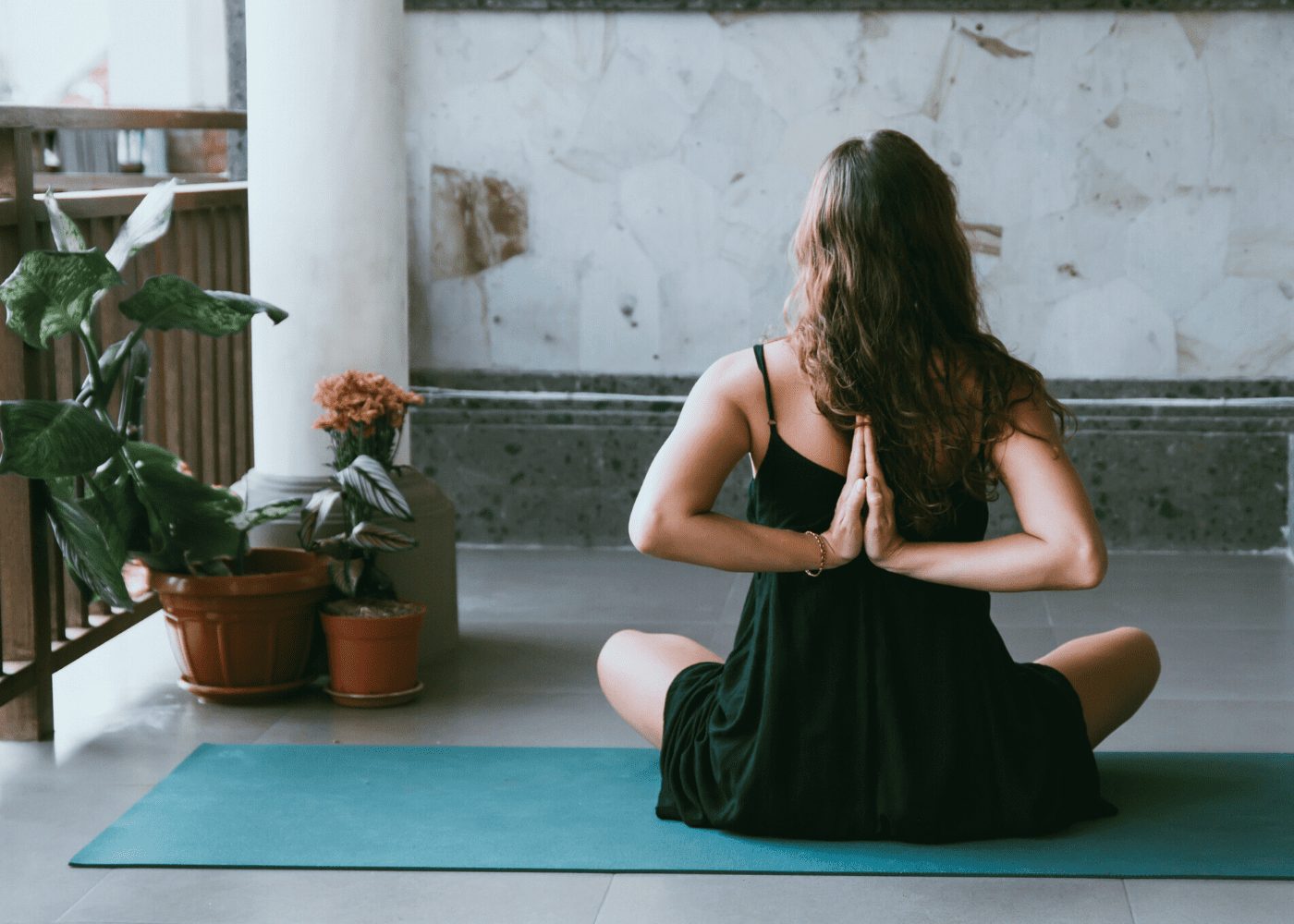 woman sitting on mat doing yoga