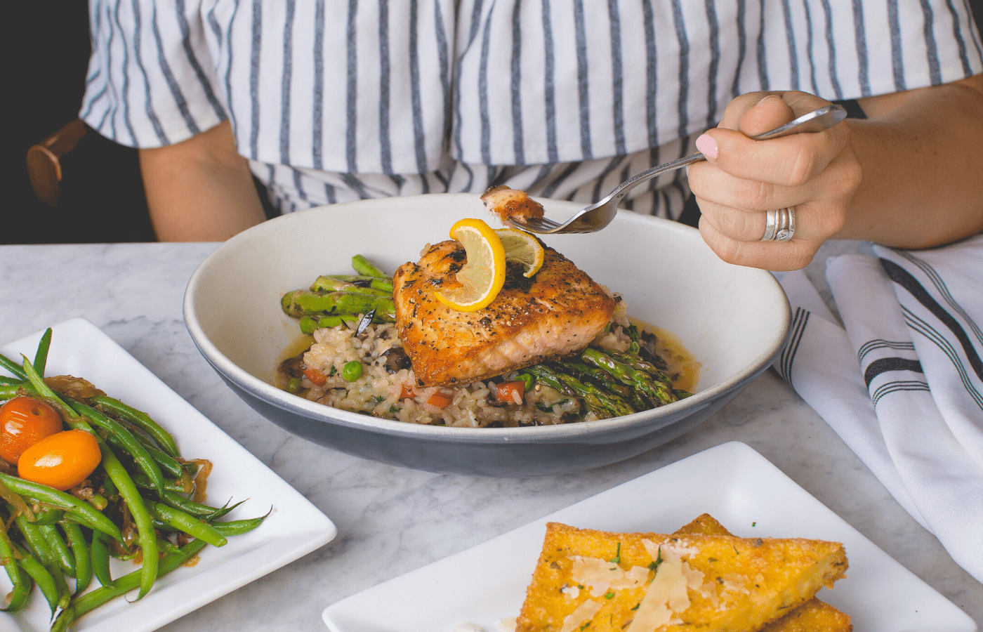 woman eating salmon on plate