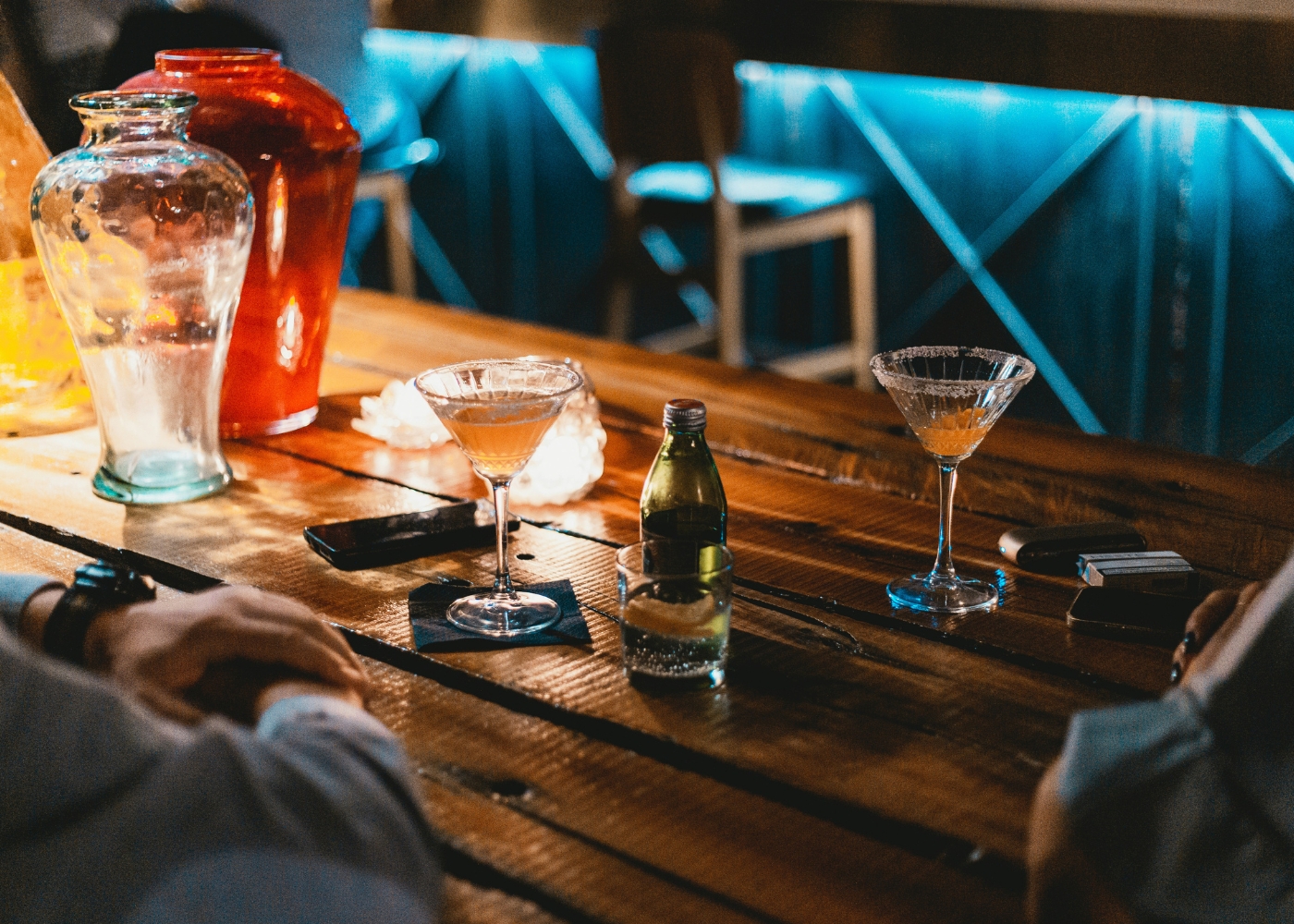 Romantic bars in Singapore - A couple seated at a bar with cocktails