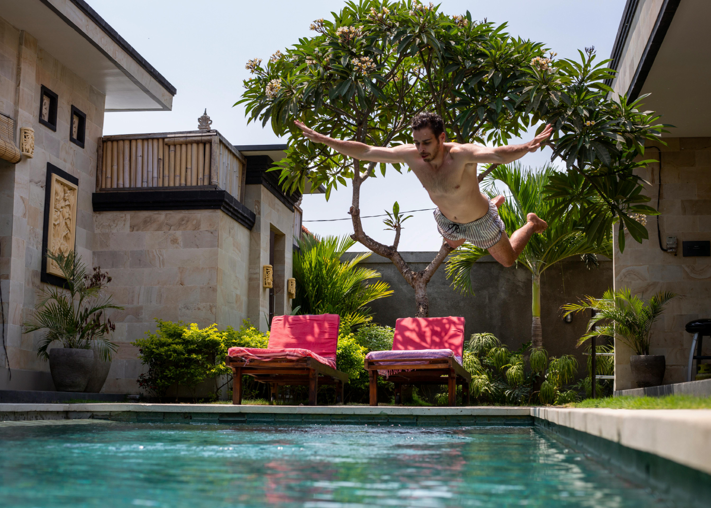 Man jumping into pool in Bali | Short weekend getaway trips from Singapore