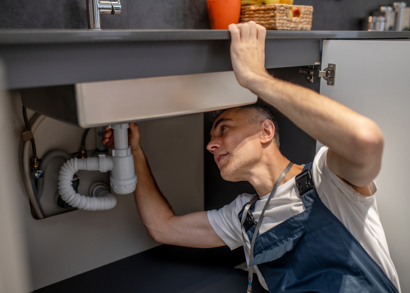 Best plumbers in Singapore - Man working on plumbing system under the sink