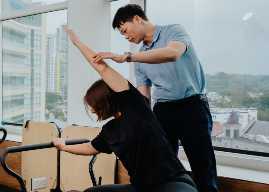 physiotherapists-singapore-city-osteopathy-and-physiotherapy-male-specialist-aiding-client