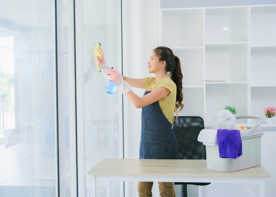 Spring cleaning services Singapore - A woman cleaning sliding glass door at home