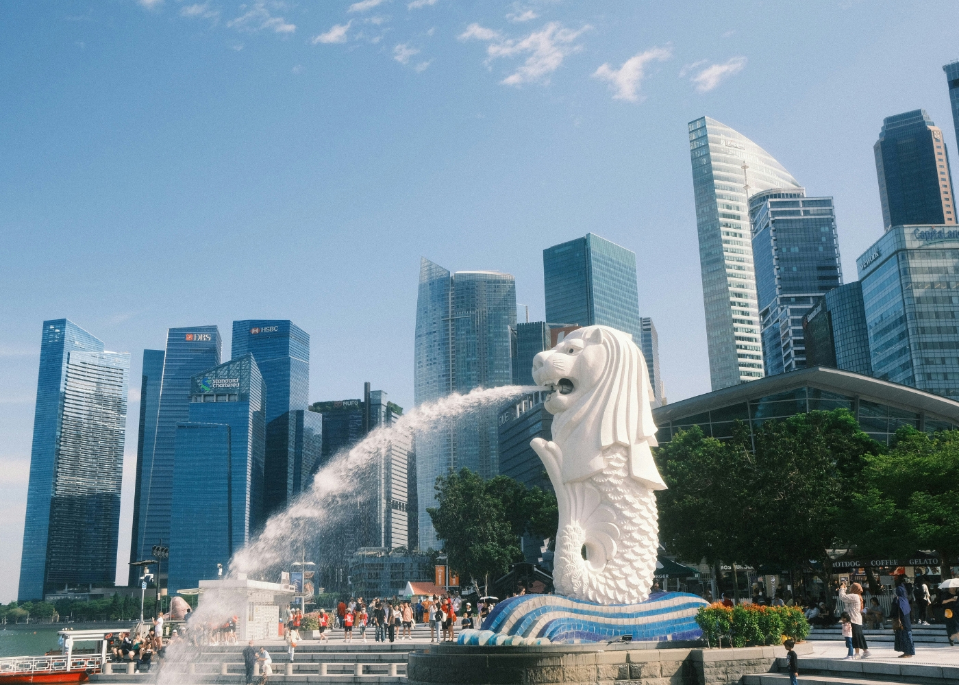 Best attractions in Singapore - Merlion spewing water against the city skyline