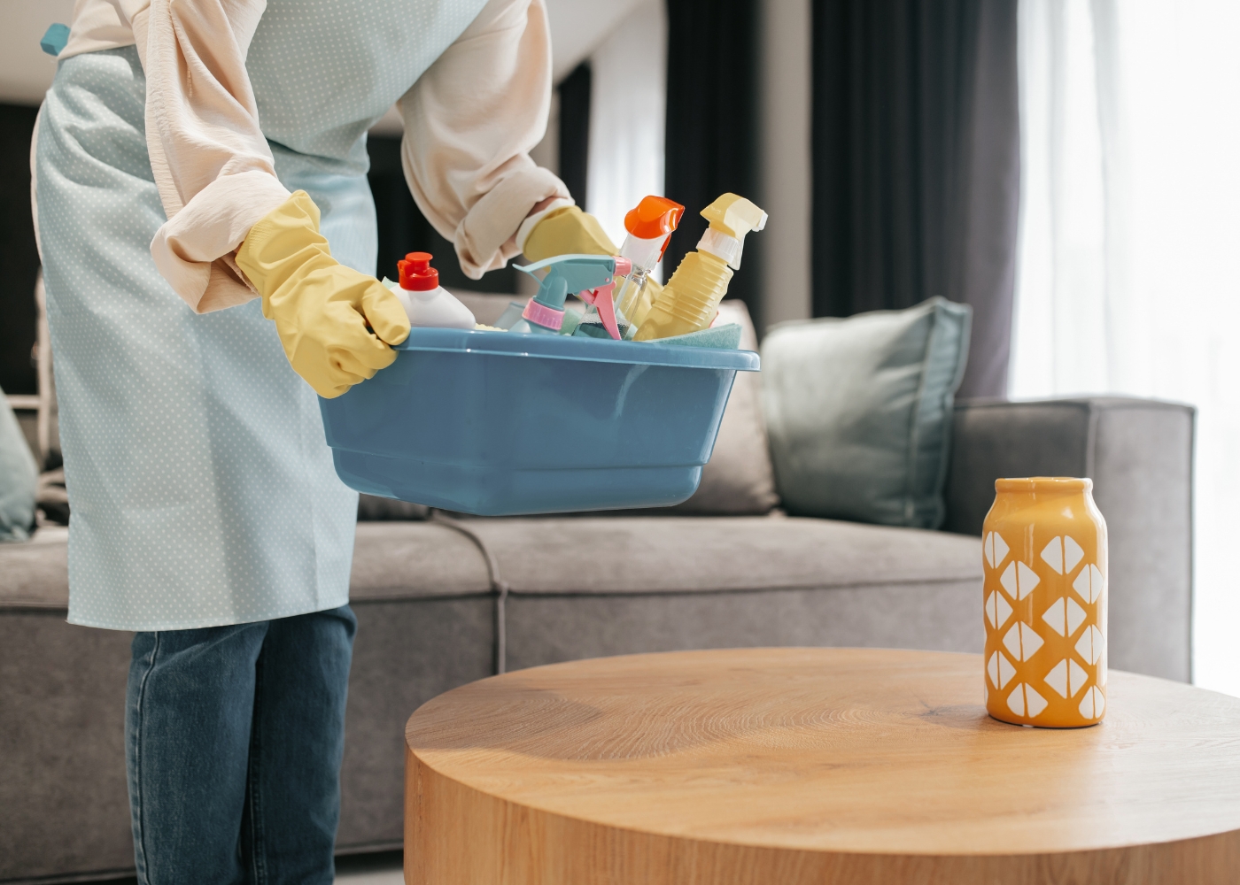 Best home cleaning services in Singapore - Half-body shot of a woman carrying a basin of disinfection and cleaning supplies