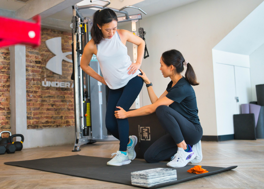 Best personal trainers in Singapore - UFIT female coach guiding female client on form