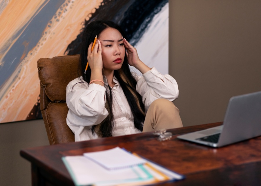 Eczema - Medium shot of woman looking stressed out at work