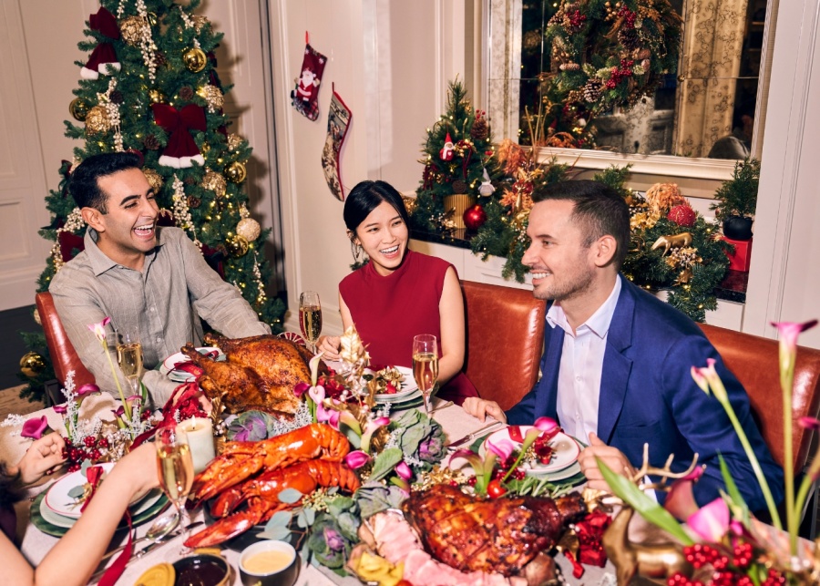 Best Christmas food delivery in Singapore 2025 - Raffles Hotel Singapore - group of friends crowding over a festive spread