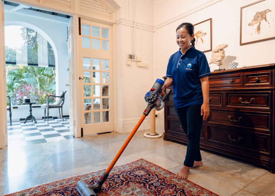 Best home cleaning services in Singapore - Nimbus Homes staff using the vacuum in a living room