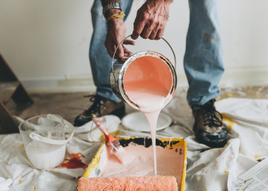 First-time home buyer mistakes - Mid-shot of a person pouring pink paint from a bucket