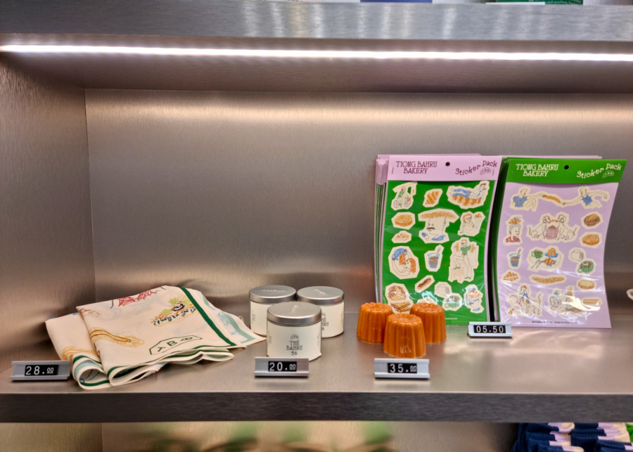 Exclusive merch like scarves, candles, canele-shaped incense holders, and stickers | Crumb & Go