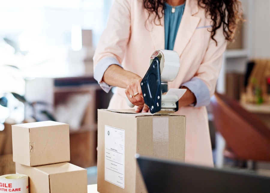 Best professional office movers in Singapore - A half-body shot of a woman packing items into boxes