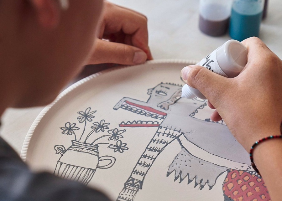 A kid painting ceramic plate in class at Kevala Studio in Sanur Bali Indonesia