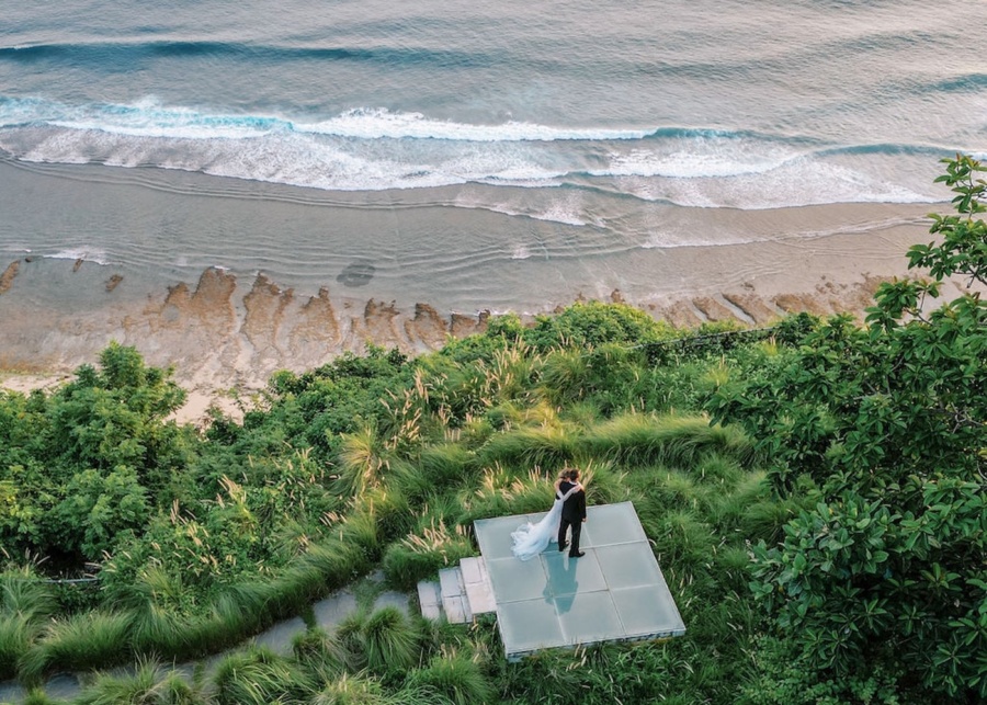 A couple looking over the ocean at Tirtha Bali – a destination wedding venue in Uluwatu, Bali, Indonesia