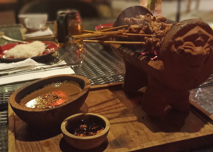 Chicken Satay on a clay grill with peanut sauce served at Jungle Tree restaurant in Sanur, Bali, Indonesia
