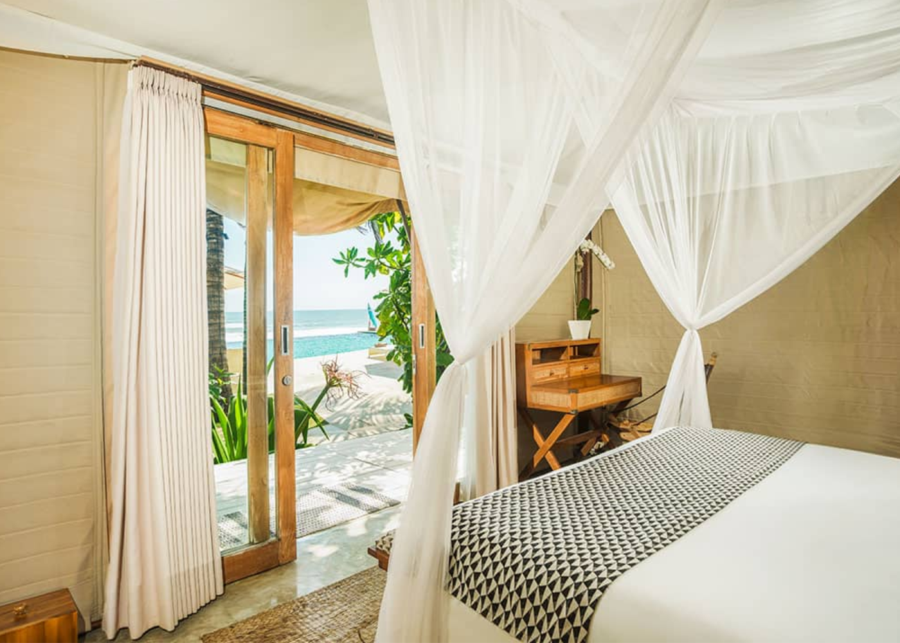 Luxury safari-style tent bedroom at Bali Beach Glamping resort in Tabanan overlooking Bali’s west coast beach.