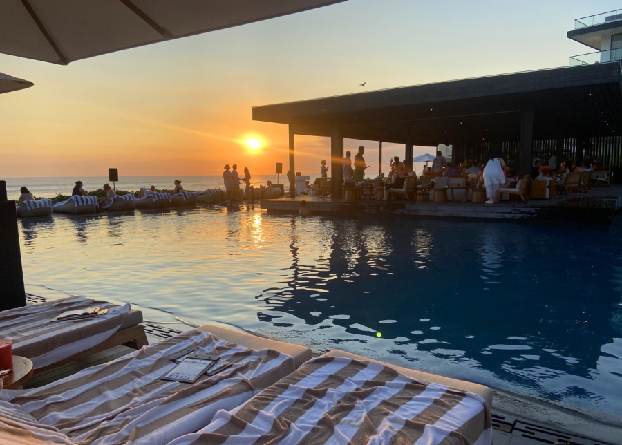 the infinity pool at the beach bar in Alila Seminyak hotel, Bali, with beach views at sunset
