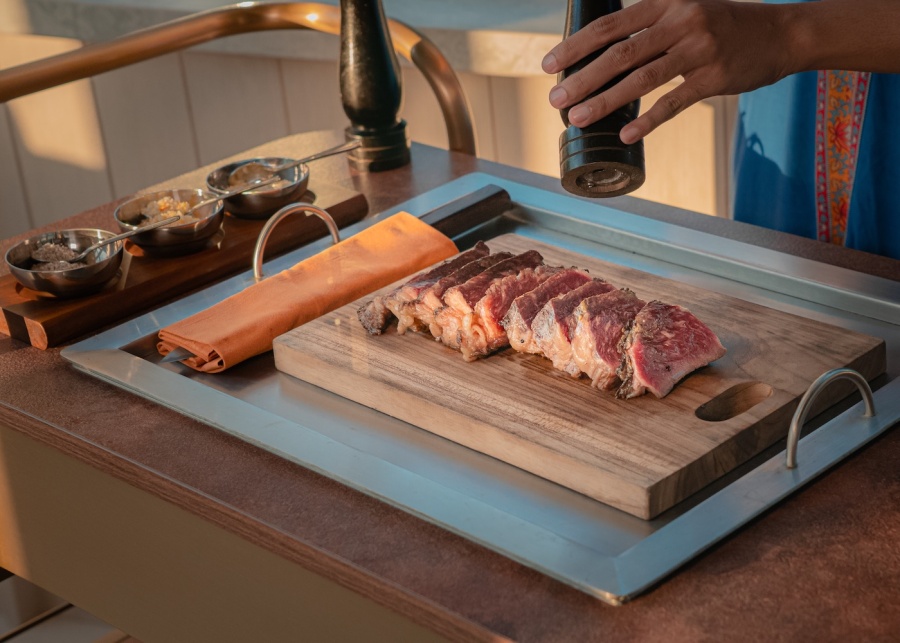 Fresh Steak being cut at sunset at SKAI Bar & Grill at Padma Resort Legian, Kuta, Bali, Indonesia