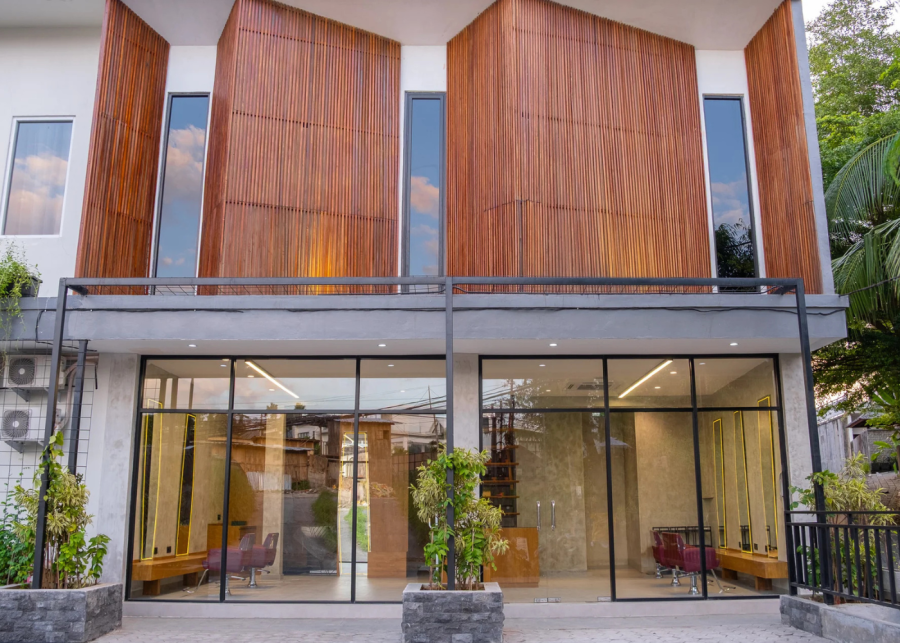 Exterior of Rob Peetoom Canggu salon with modern architecture and warm wooden paneling.