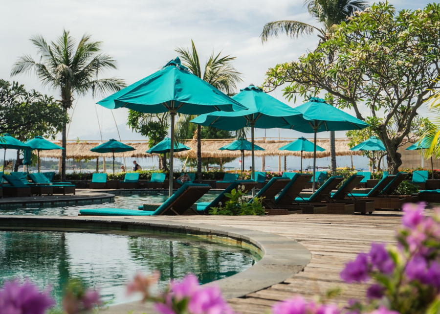 The swimming pool, sundeck and turquoise sun loungers by the beach at Hotel Vila Ombak in Gili Trawangan, Lombok, Indonesia