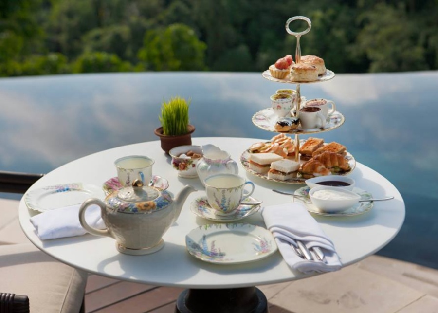 Multi-tiered sweets and savoury bites served for afternoon tea by the pool at Hanging Gardens Bali in Ubud