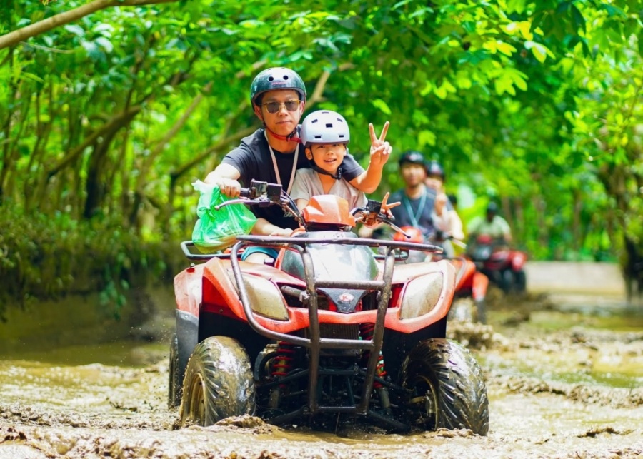 Dad and kid riding a tandem ATV with Alasan Adventure in Ubud - best things to do in Bali with kids