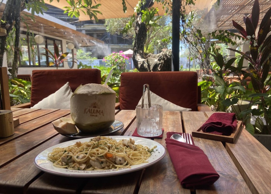 Spaghetti aglio olio and whole young coconut at Kaluma restaurant in Sanur, Bali, Indonesia