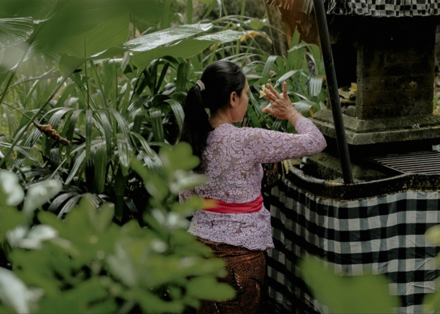 a person doing Sandikala, a traditional Balinese ritual of gratitude at the camp temple. 