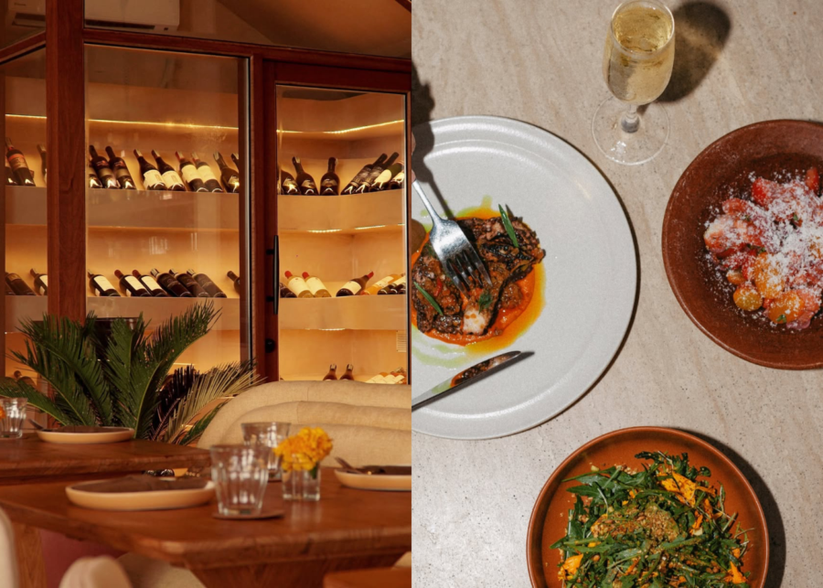 A lit wine cabinet beside a candlelit table at Teja Uluwatu, with an overhead spread of fish in romesco, a tomato salad and greens, and a glass of white wine.