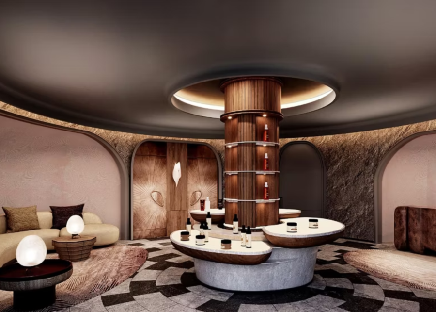 Cave-like spa interior at Akila Dome with curved wooden tower, arched doorways, and skincare products displayed on stone tables.