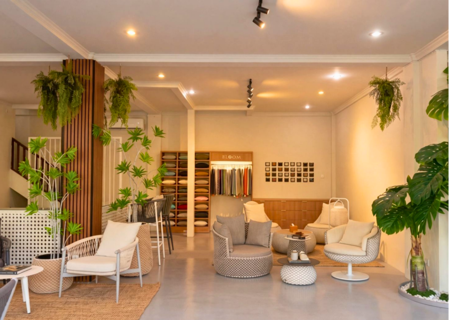 BLOOM outdoor furniture showroom in Seminyak, with rattan lounge chairs, ottomans and a wall of fabric swatches and cushions.