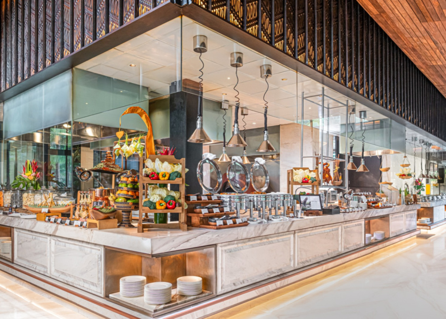 Indoor dining space and open kitchen with Christmas brunch display at Pala Restaurant at The Apurva Kempinski Bali resort in Nusa Dua