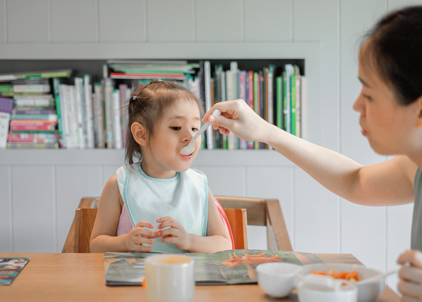 raising a veggie family in Hong Kong spoon feeding little girl