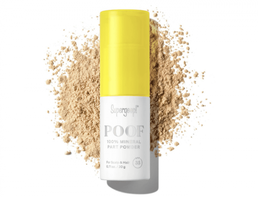 a bottle of dry shampoo with powder behind it