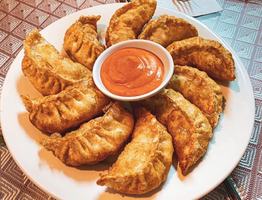 a plate of fried momos and chilli garlic chutney