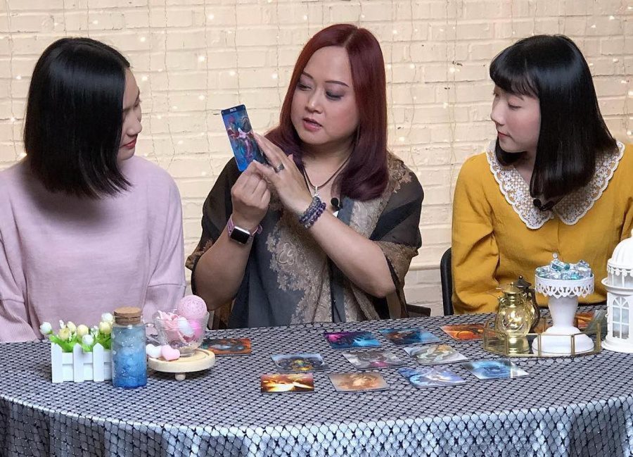 Fanny Wu with two clients and crystals and tarot cards on the table