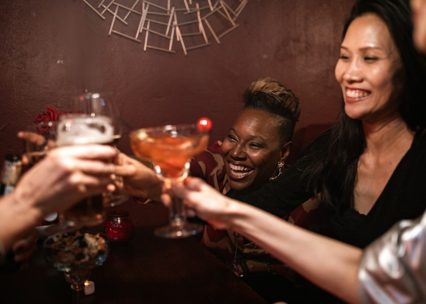 people in a circle clinking drinks